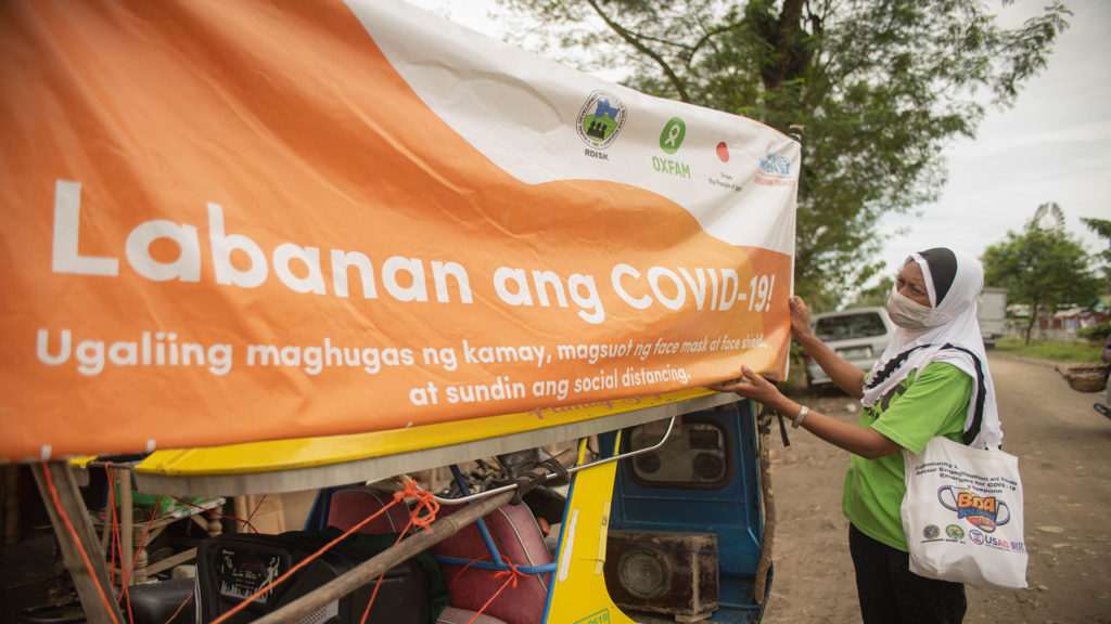 Hasna Tuwa fixes the tarp of the mobile live public announcement platform known as the rekorida before roaming around Datu Abdullah Sangki, Maguindanao. (Photo: Princess Taroza/Oxfam)