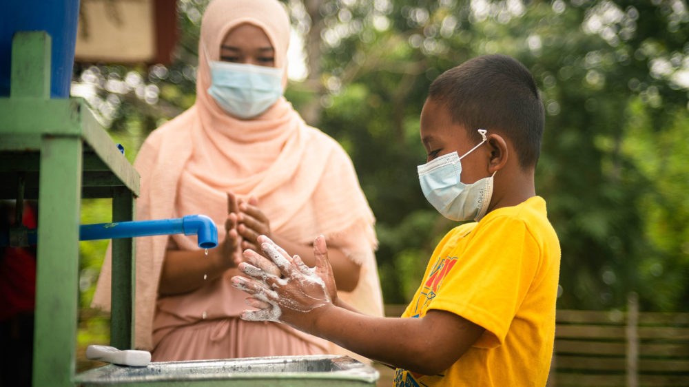 Jehana Pagabangan, one of the Mum's Magic Hands (MMH) champions, teaches Mamami Piang the proper handwashing in Sultan sa Barongis, Maguindanao. (Photo: Princess Tarroza/Oxfam)