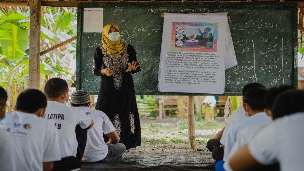 Norhaimin Omar, a youth MMH champion, teaches students the importance of cleanliness in Dar Al-Ziker Holy Qur'an Memorization Center at Shariff Saydona Mustapha, Maguindanao. (Photo: Princess Taroza/Oxfam)