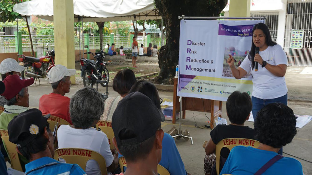 Ana RiaBarrera explains the concepts of disaster risk reduction to farmers affected by Typhoon Mangkhutduring a community cash card distribution in Enrile, Cagayanwith the support of Oxfam. (Photo: Denvie Balidoy/Oxfam)