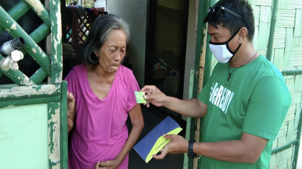 B-READY participant receives her prepaid card in Barangay Burak, Salcedo, Eastern Samar. (Photo: Myleen Ogana, PDRRN)