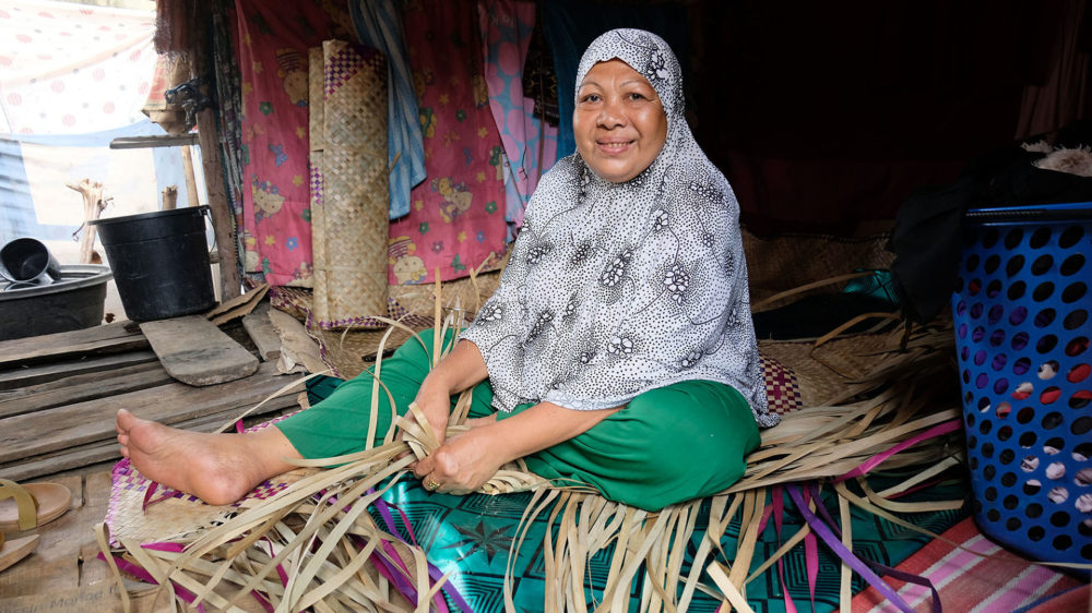 Zulaika Lamikan, 53, an “ikam” or mat weaver, is grateful for the solar-powered lamp that helps her weave even at night. The lamps were provided by the REACH Project. (Bong Sarmiento/Oxfam Pilipinas)