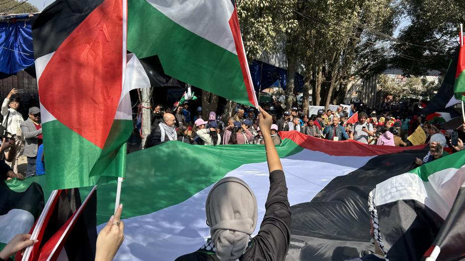 A protest with Palestinian flags being waved by several people