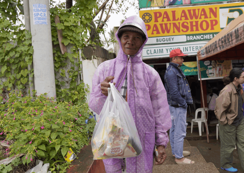 An elderly Indigenous woman purchases food ahead of Cyclone Trami’s landfall in the Philippines. Credit: Humanity & Inclusion